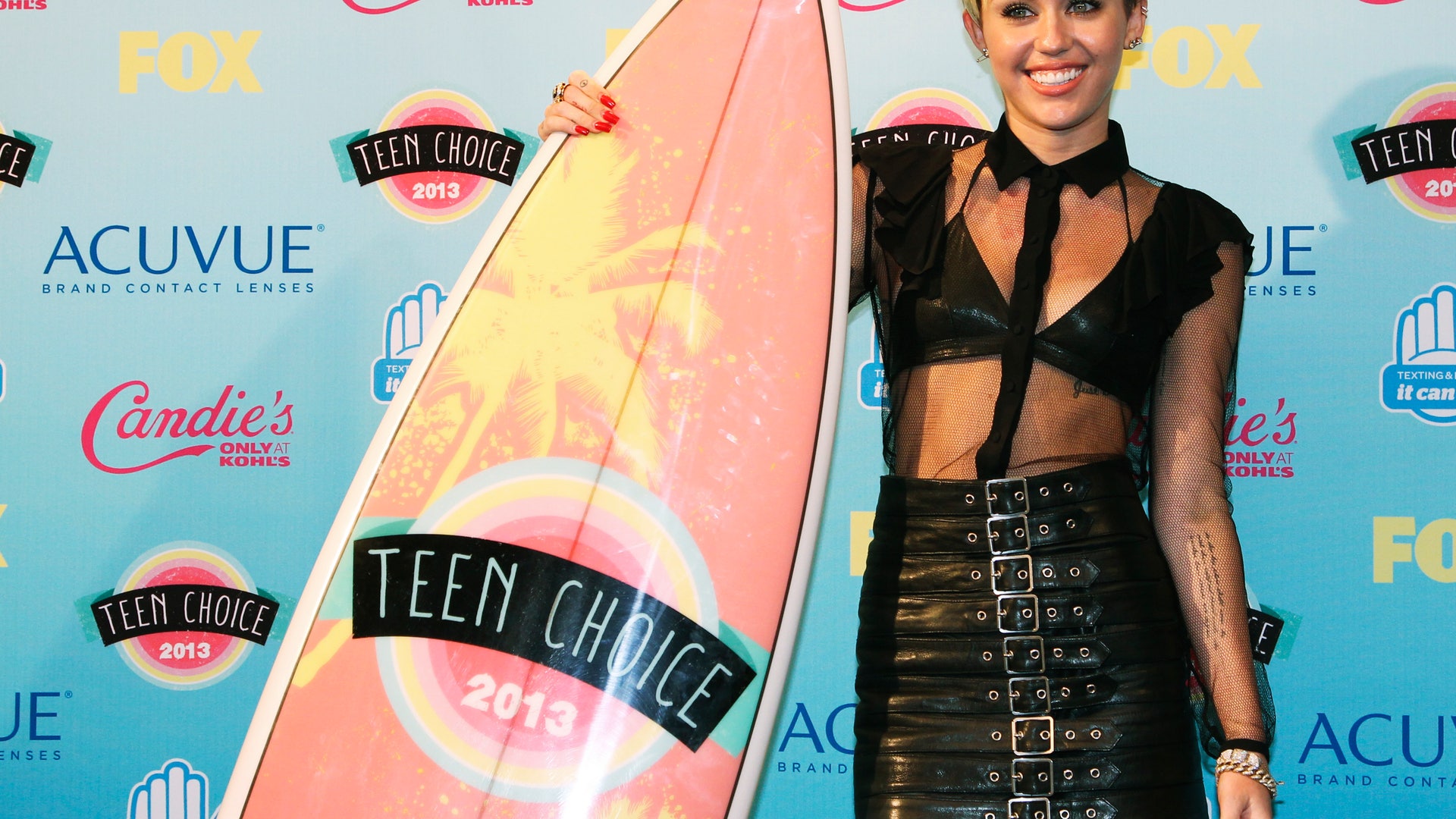 Actress and singer Miley Cyrus poses for photographers after being named this years' Candies' Choice Style Icon at the Teen Choice Awards at the Gibson amphitheatre in Universal City, California  August 11, 2013. REUTERS/Fred Prouser (UNITED STATES - Tags: ENTERTAINMENT) - RTX12HWU