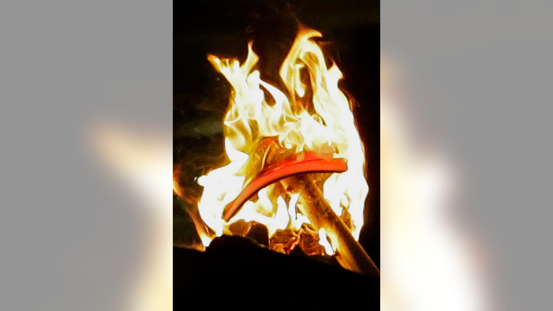 A hat with President Donald Trump's presidential campaign slogan on it is set ablaze during rally.