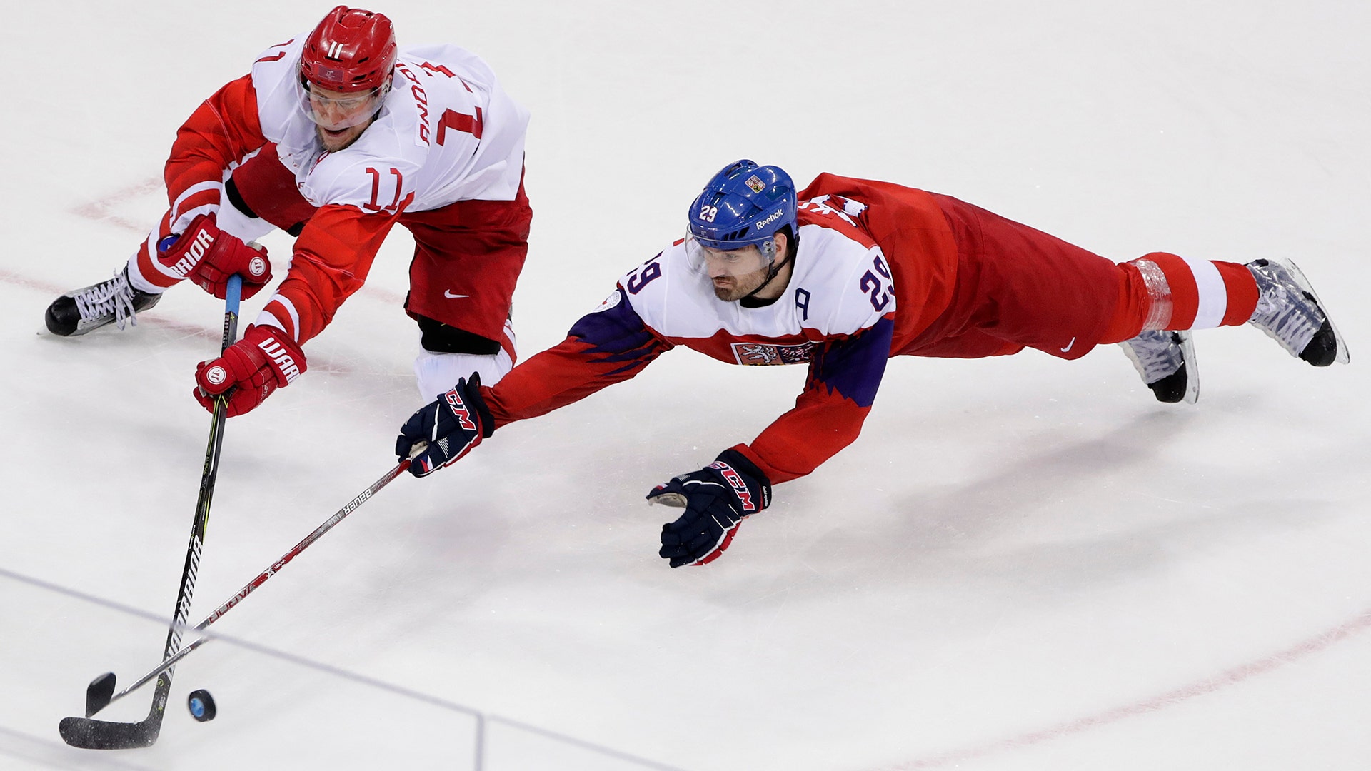 Russian Sergei Andronov and Jan Kolar of the Czech Republic, battle for the puck in their semi-final ice hockey match at the Winter Olympics