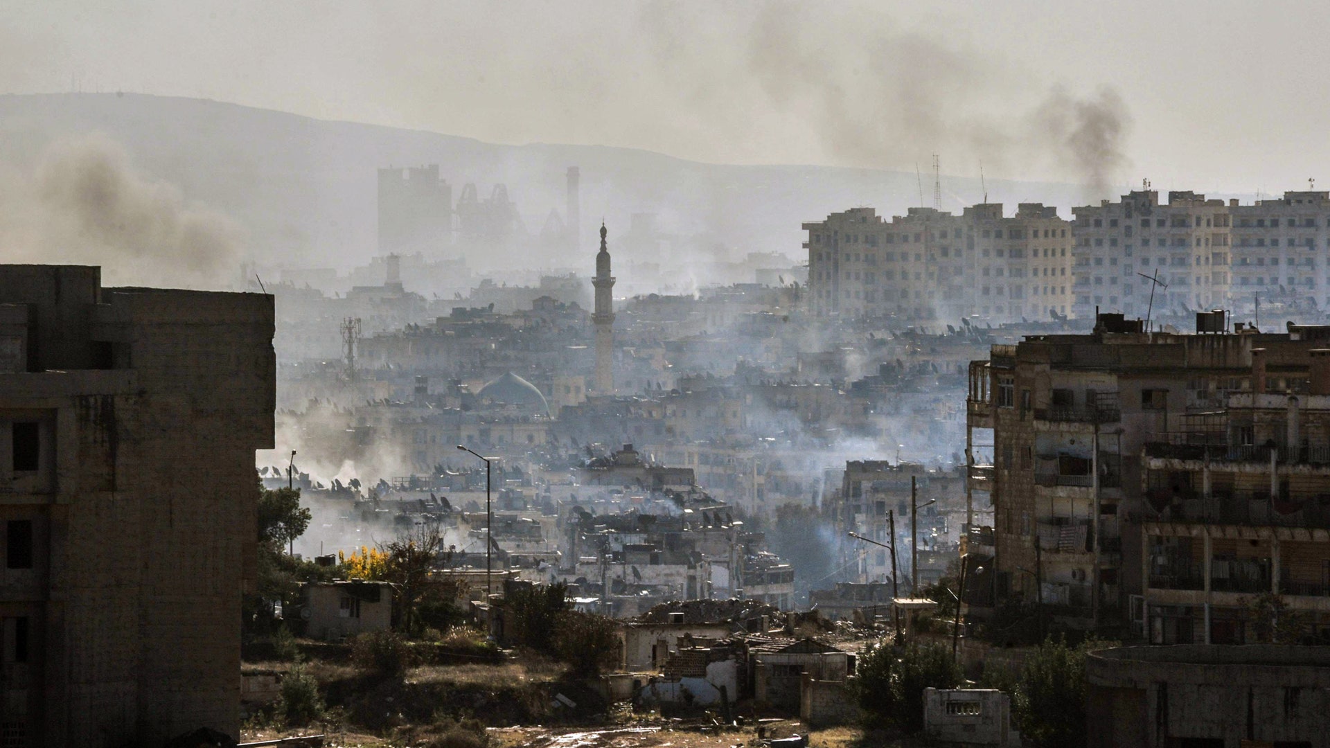 Smoke rises in an east Aleppo neighborhood in Syria, Thursday, Dec. 15, 2016, in this photo released by the Syrian official news agency SANA.
