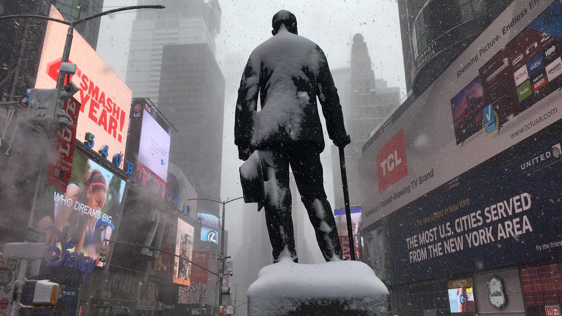 A statue of George M. Cohan stands in Times Square as snow falls in New York.
