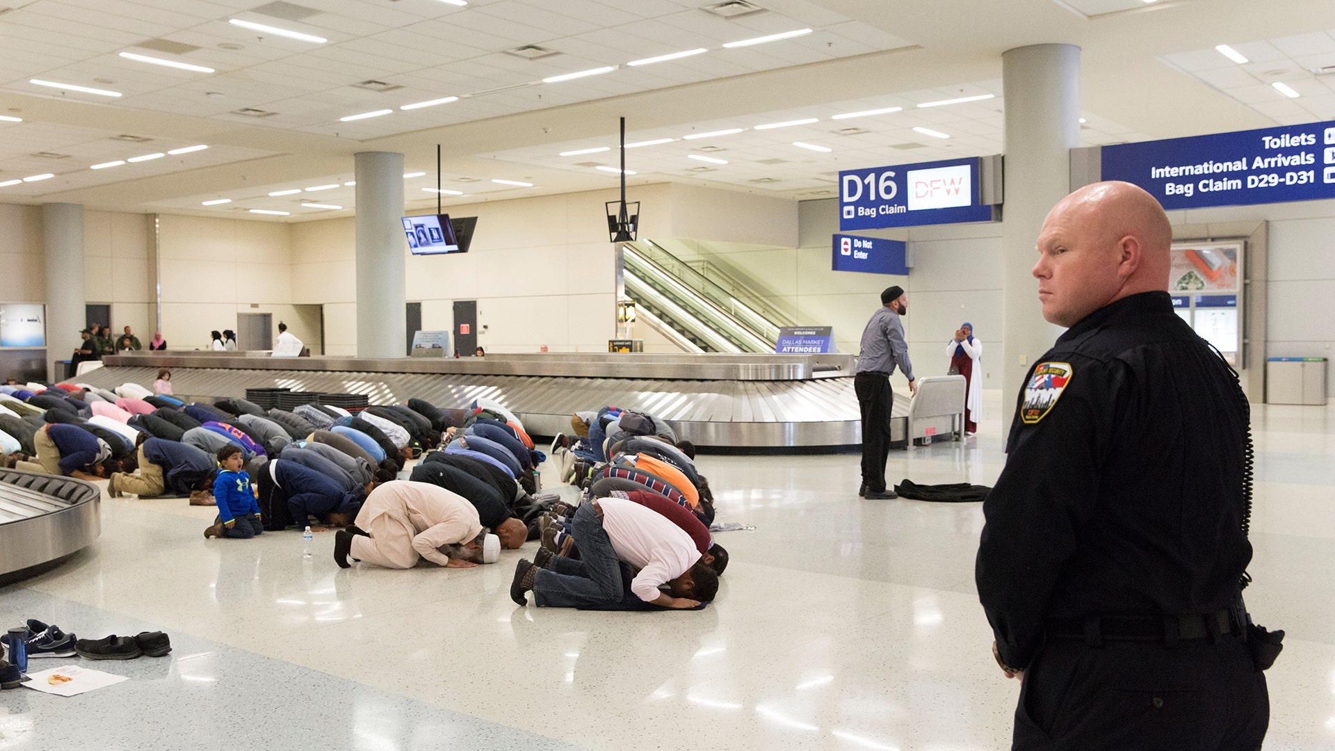 People gather to pray in baggage claim during a protest against the travel ban imposed by U.S. President Donald Trump's executive order, at Dallas/Fort Worth International Airport in Dallas, Texas.