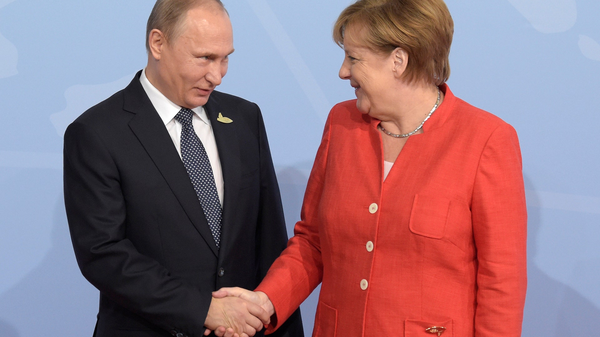 Russian President Vladimir Putin shakes hands with German Chancellor Angela Merkel at the G-20 summit in Hamburg, Germany