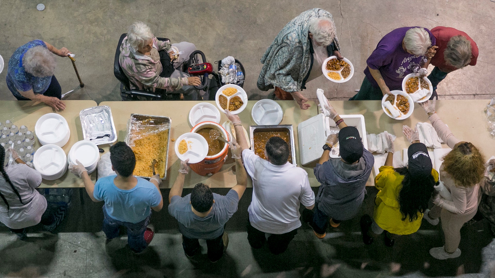 Volunteers serve dinner to flood victims at the Beaumont Civic Center in Beaumont, Texas, Wednesday