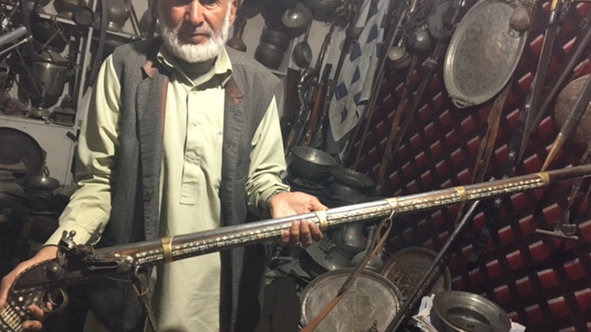 Antique gun store's owner, Tawakal, holds the handmade 