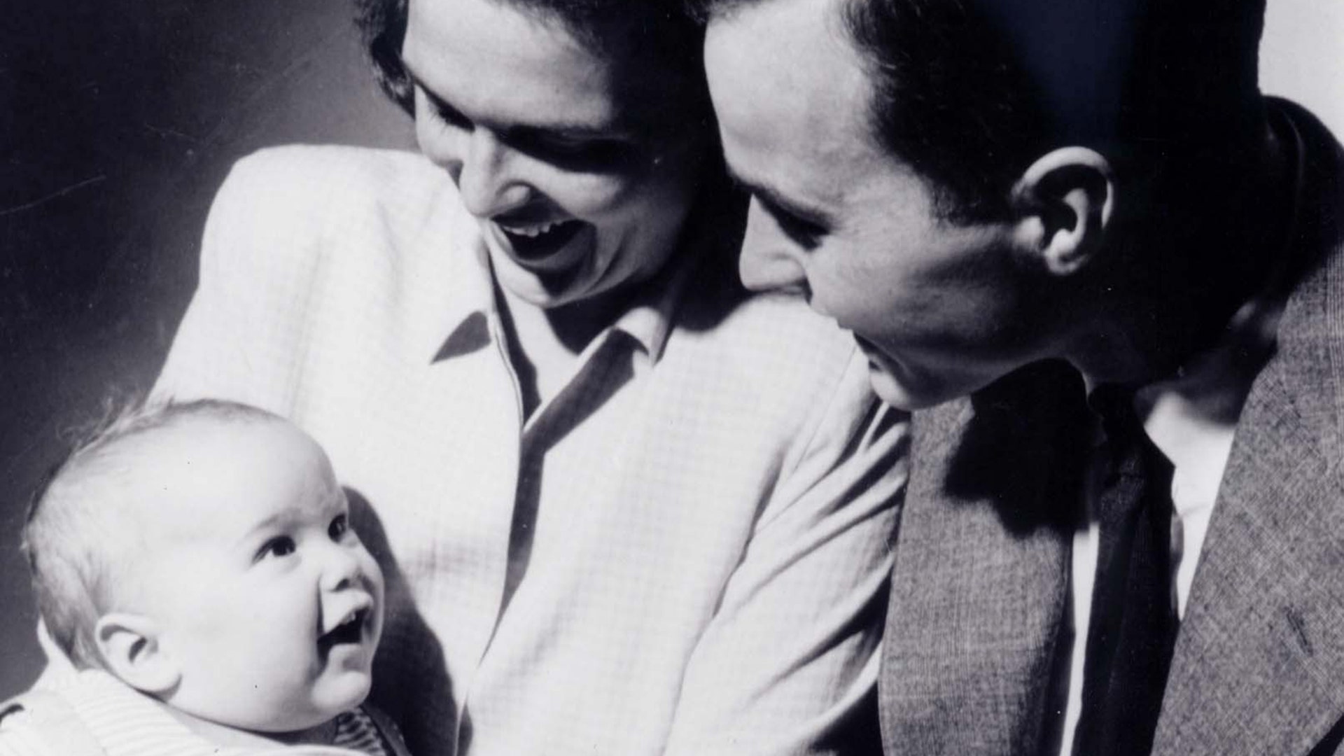 Barbara Bush holds son George W. Bush as the future President George Bush looks on in New Haven, Connecticut