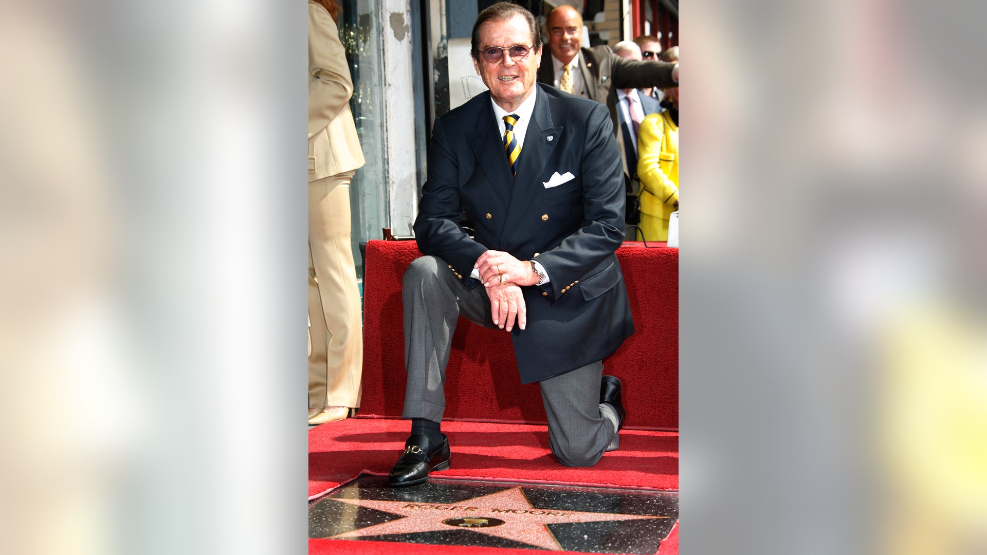 Moore kneels in front of his newly unveiled star on the Hollywood Walk of Fame on October 11, 2007