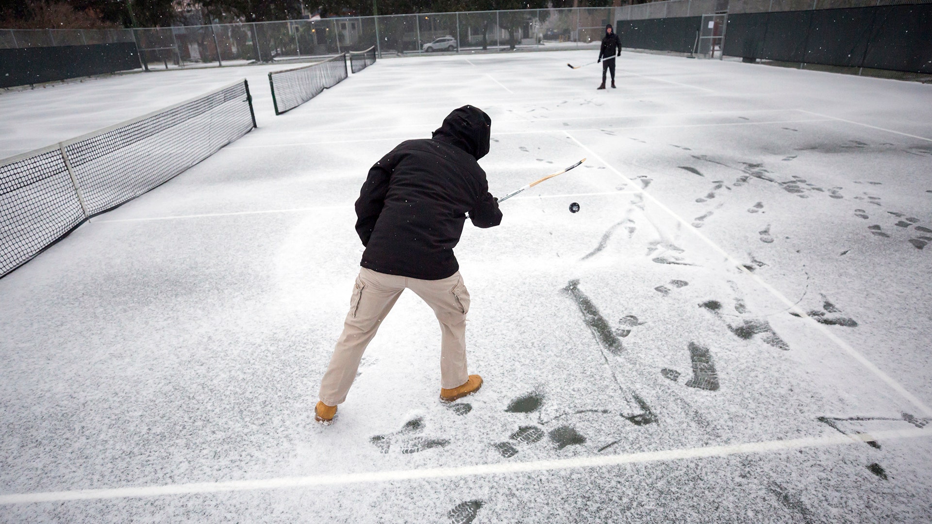 Vincent Sottile, center, and his brother Mike Sottile play hockey on the public tennis courts at Forsyth Park, in Savannah, Ga