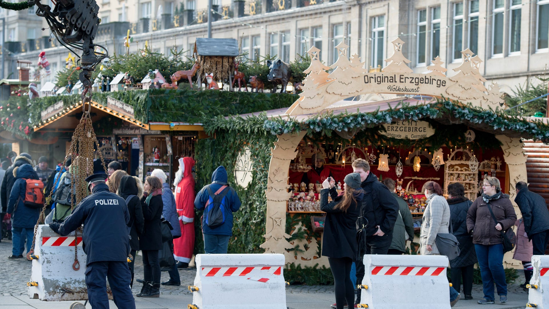 A police officer positions concrete blocks at an entrance to the Striezelmarkt Christmas market in Dresden, eastern Germany, Tuesday Dec. 20, 2016, after a truck ran into a crowded Christmas market in Berlin the evening before and killed several people. 