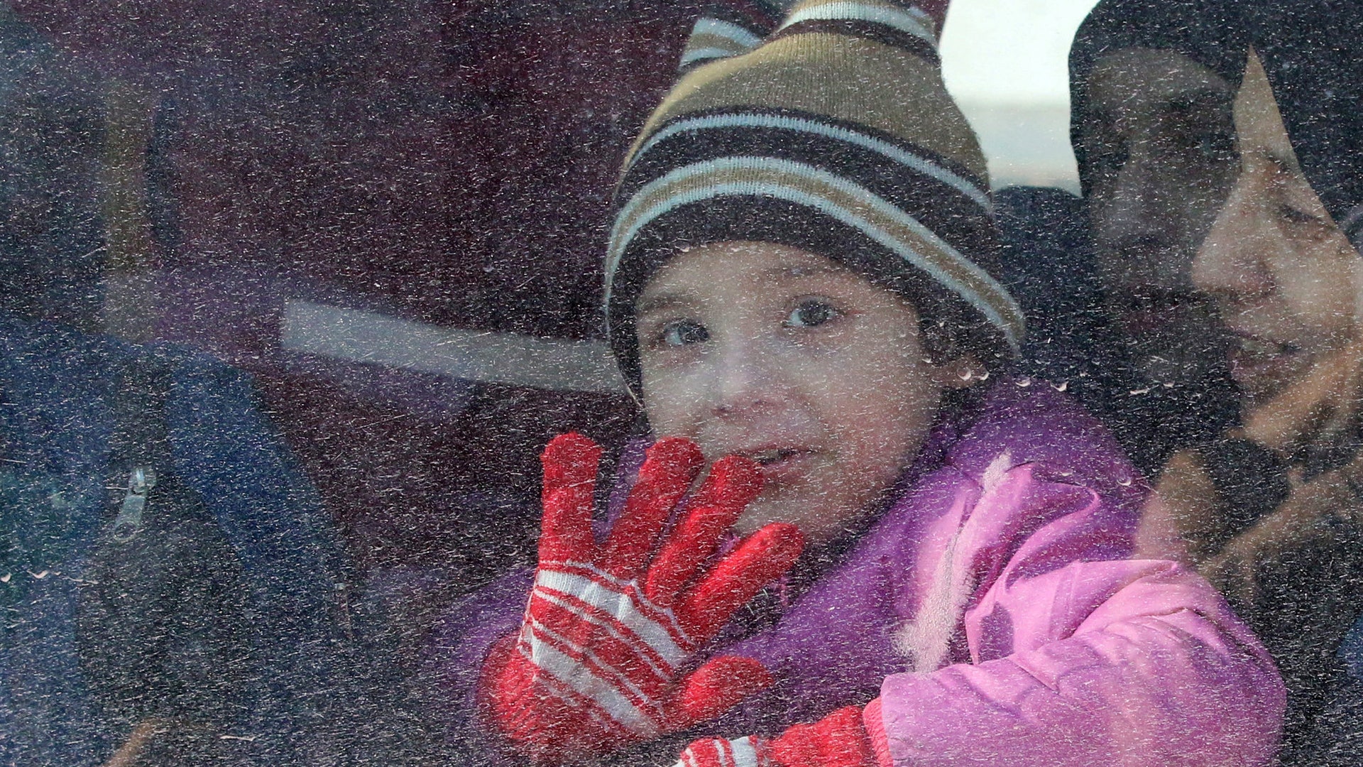 A child reacts from inside a bus evacuating people from a rebel-held sector of eastern Aleppo, Syria December 15, 2016. REUTERS/Abdalrhman Ismail 