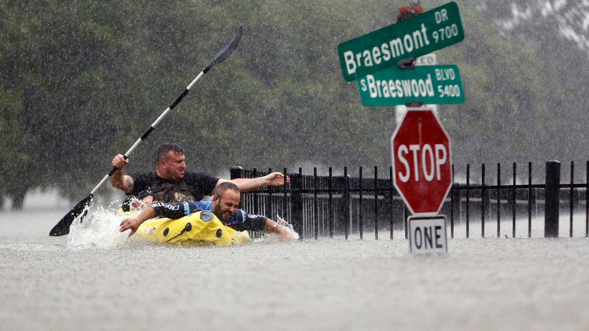 Two kayakers try to beat the current pushing them down an overflowing Brays Bayou from Tropical Storm Harvey in Houston, Texas, Sunday