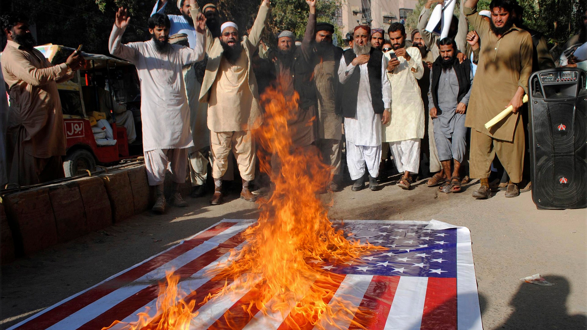 Pakistanis burn a representation of the U.S. flag during a protest rally in Hyderabad, Pakistan, December 7