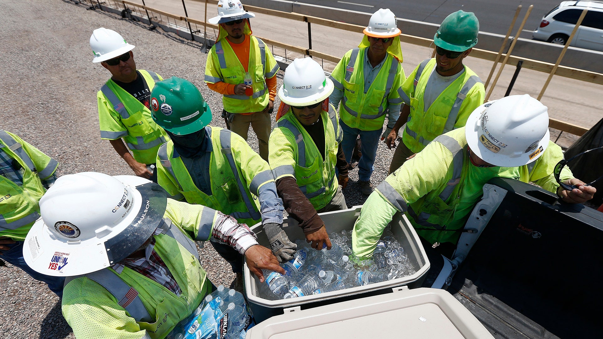 Crew members building the Loop 202 South Mountain Freeway take a break as temperatures climb to near-record highs in Phoenix, Tuesday