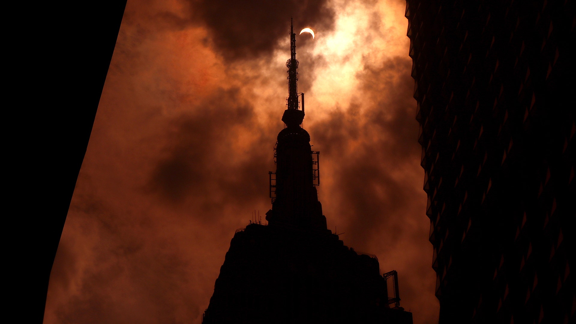 The solar eclipse is seen over the Empire State Building in New York City, August 21