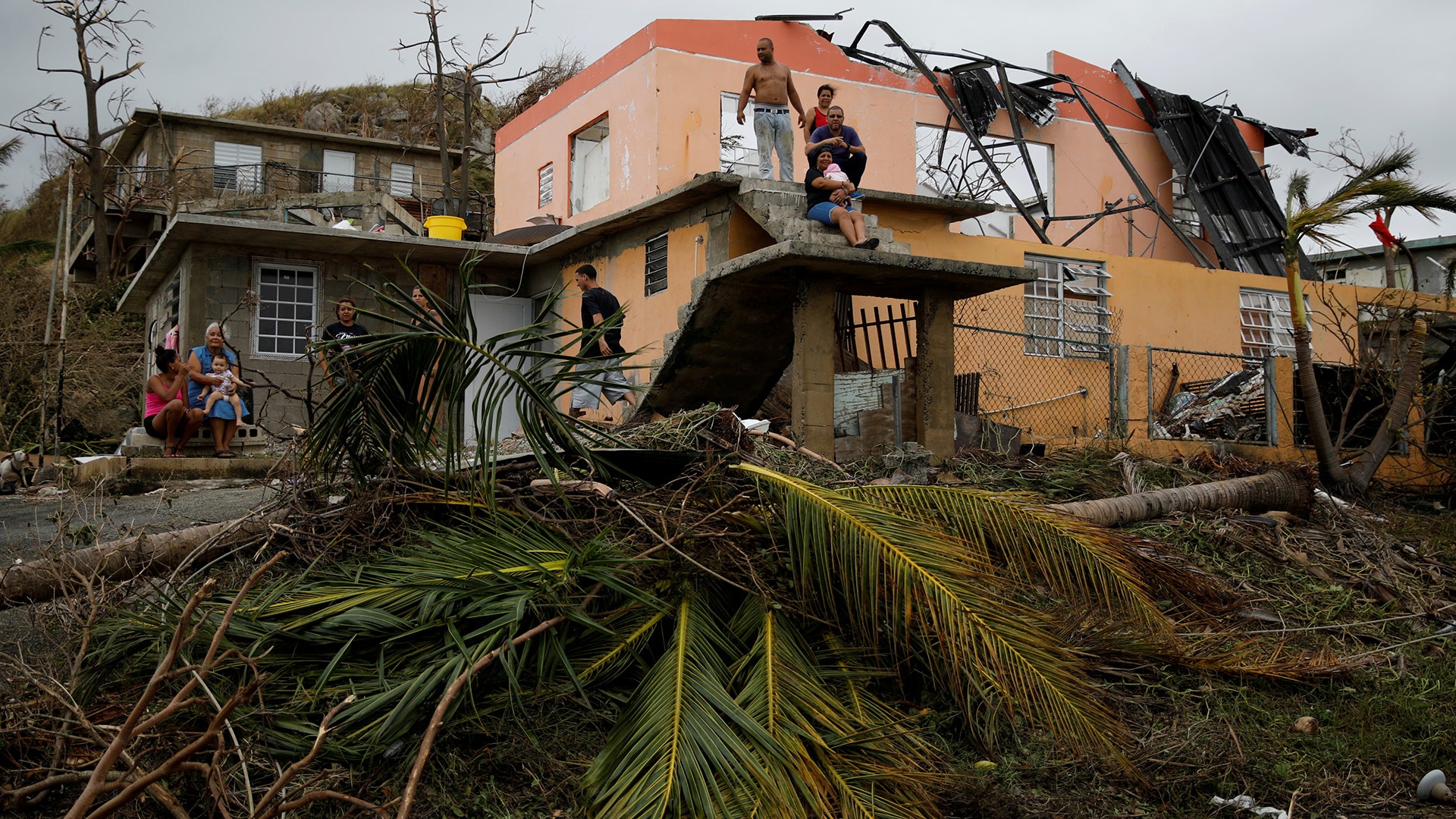 People rest outside a damaged house after the area was hit by Hurricane Maria in Yabucoa, Puerto Rico September 22, 2017