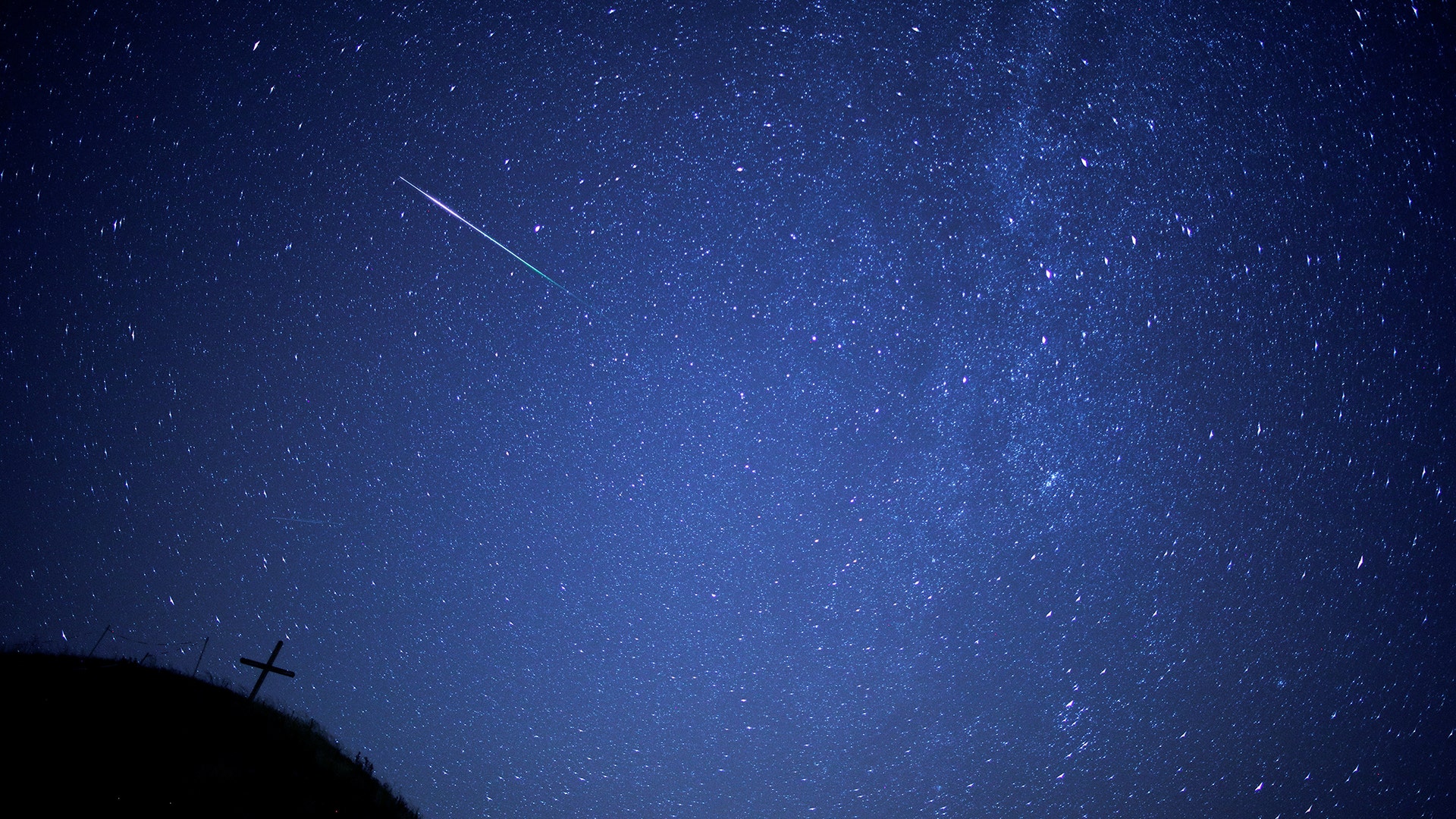 A meteor streaks past the Milky Way above Leeberg Hill during the Perseid meteor shower in Grossmugl, Austria, August 12, 2018