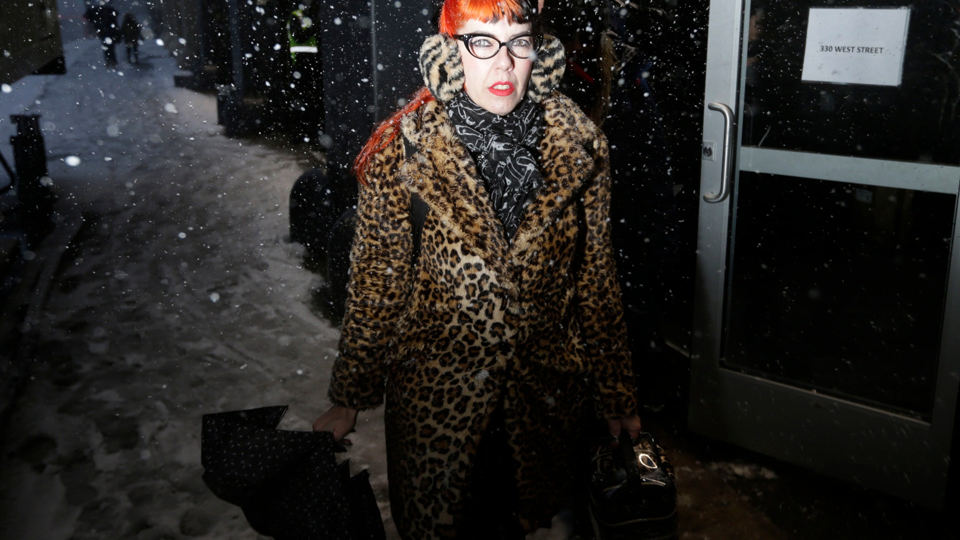 A woman working at Fashion Week makes her way to the venue through heavy snow in New York.