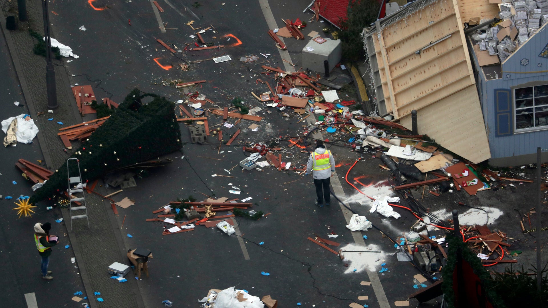 Police officers inspect the crime scene in Berlin, Germany, Tuesday, Dec. 20, 2016, the day after a truck ran into a crowded Christmas market and killed several people.