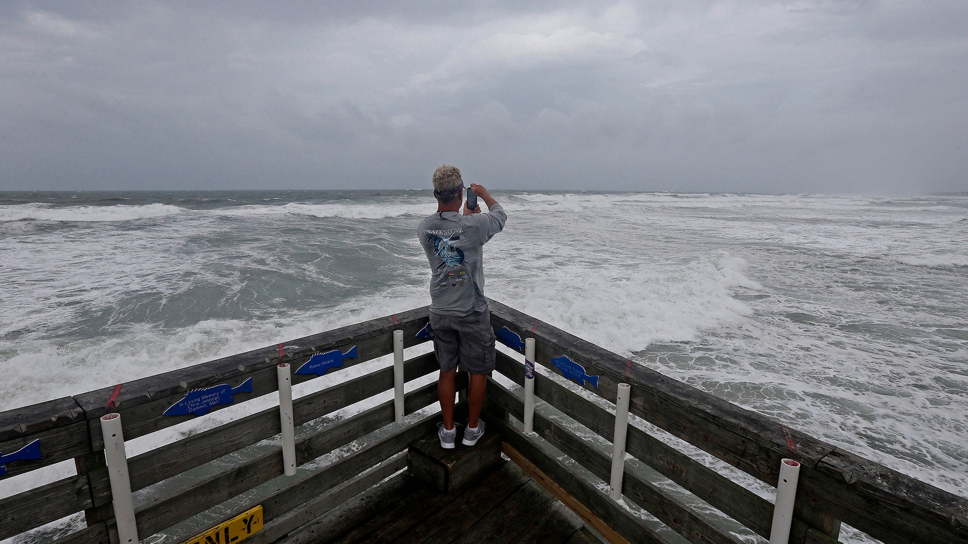Patrick Wells looks out over the Atlantic ocean at the Avalon Fishing Pier in Kill Devil Hills, North Carolina, Thursday