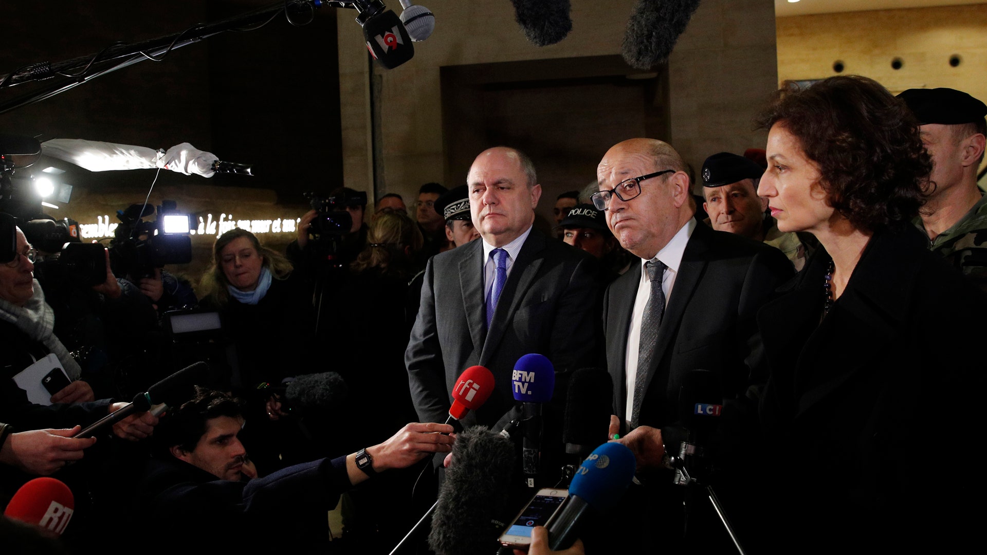 French Interior Minisnter Bruno le Roux, center left, Defense Minister Jean-Yves le Drian and Culture Minister Audrey Azoulay answer reporters inside the Louvre Museum.