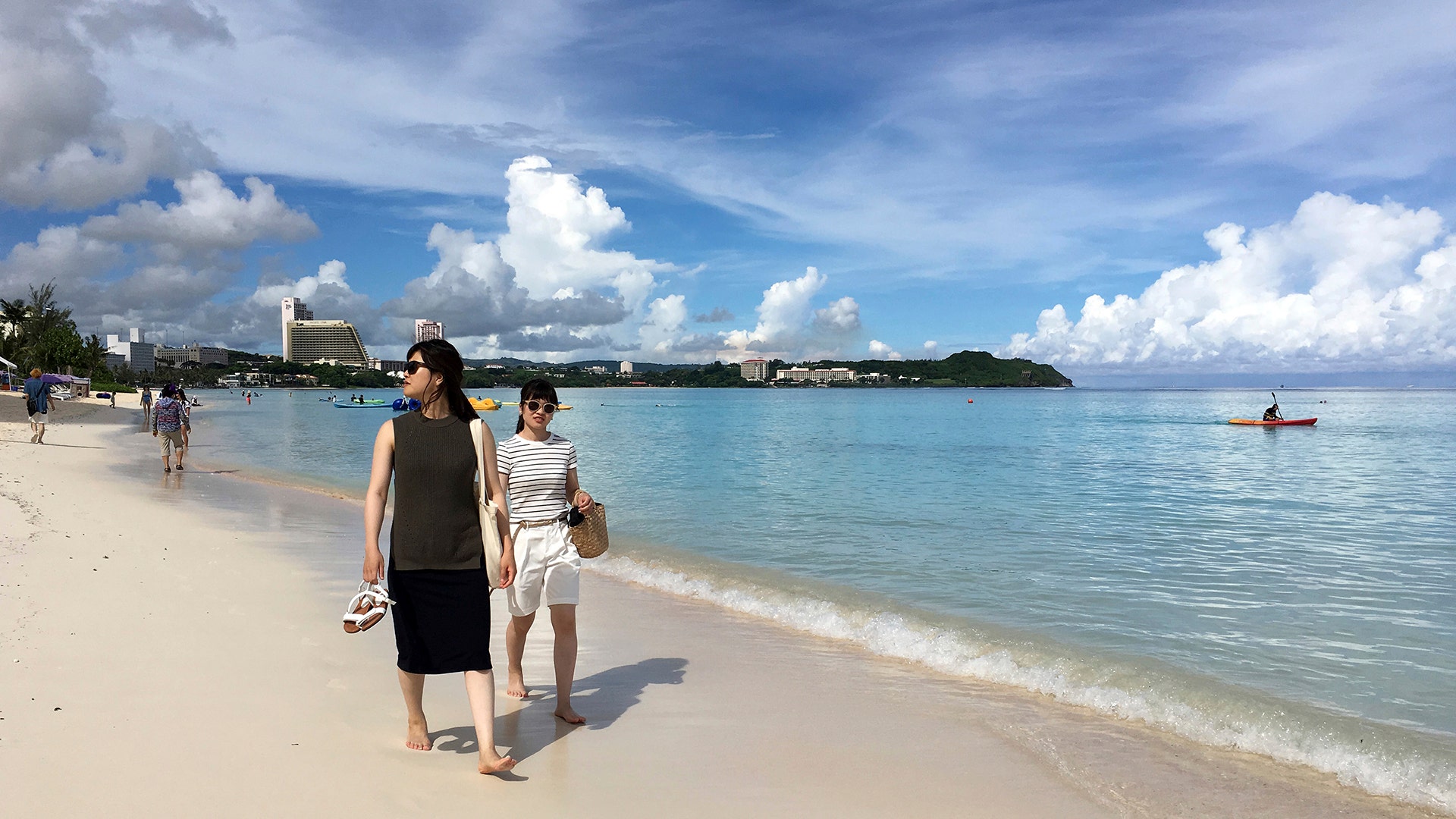 Tourists walk the beach in Tumon, Aug. 10, 2017.