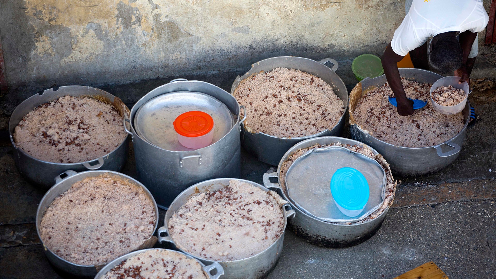 A prisoner fills his lunch bowl with rice and beans at the National Penitentiary in downtown Port-au-Prince, Haiti.