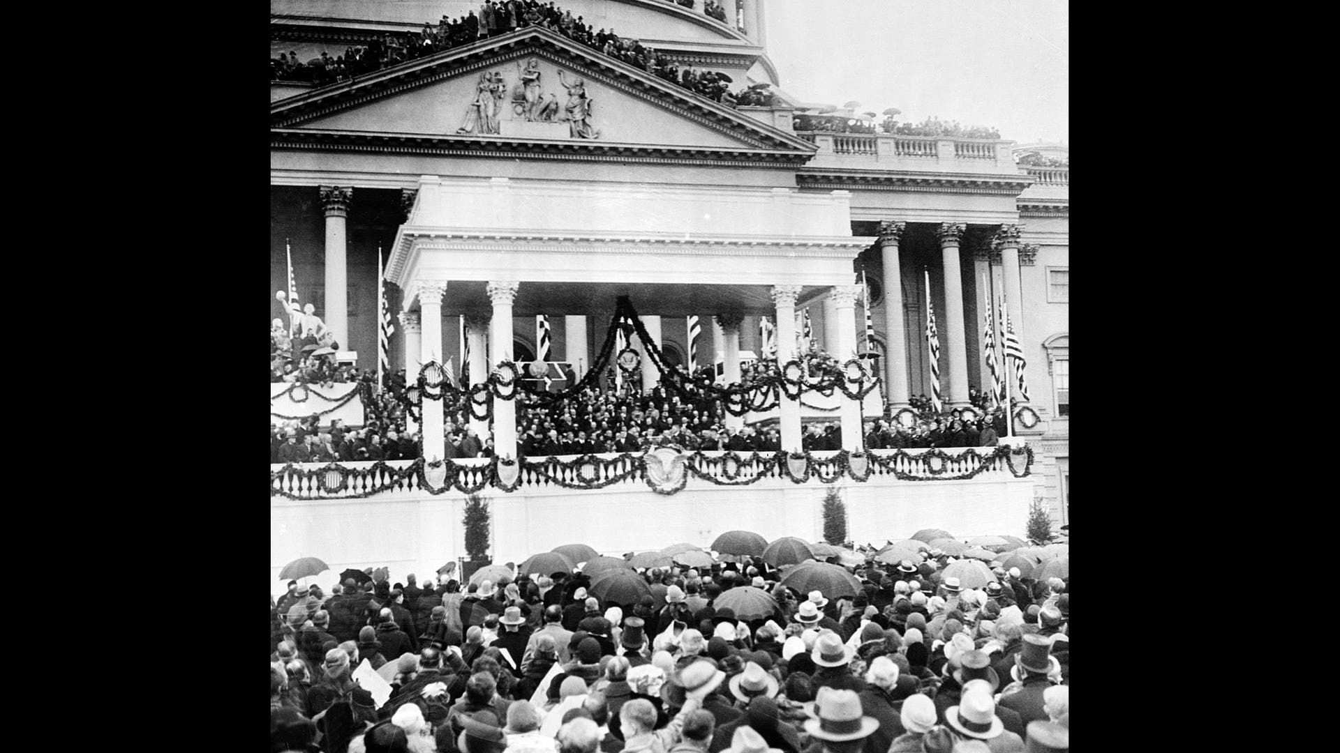 People stand in the rain for the inauguration of Herbert C. Hoover as he is sworn in as the 31st president of the United States in front of the Capitol in Washington, D.C. on March 4, 1929.