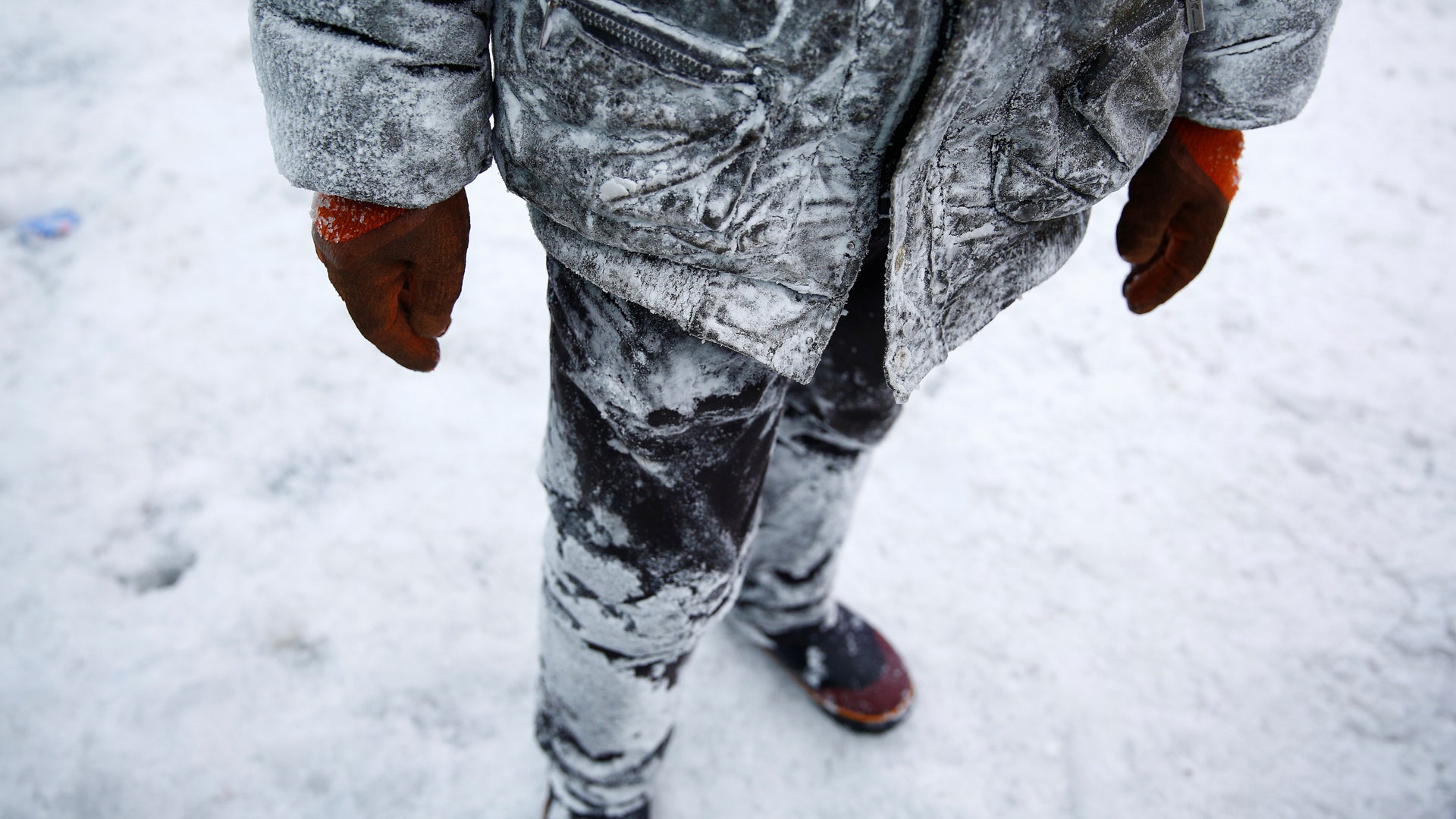 A worker poses in his frozen clothes. 