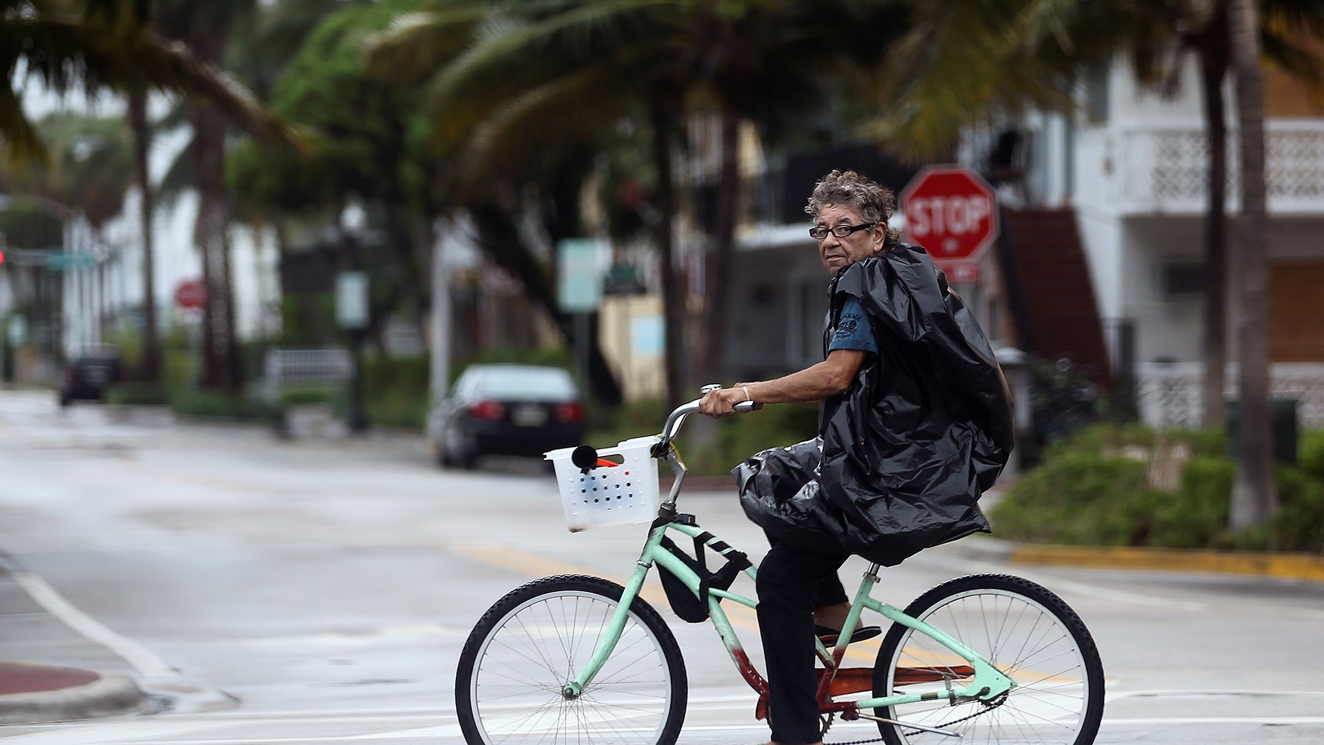 A local resident rides a bicycle along an empty street in South Beach