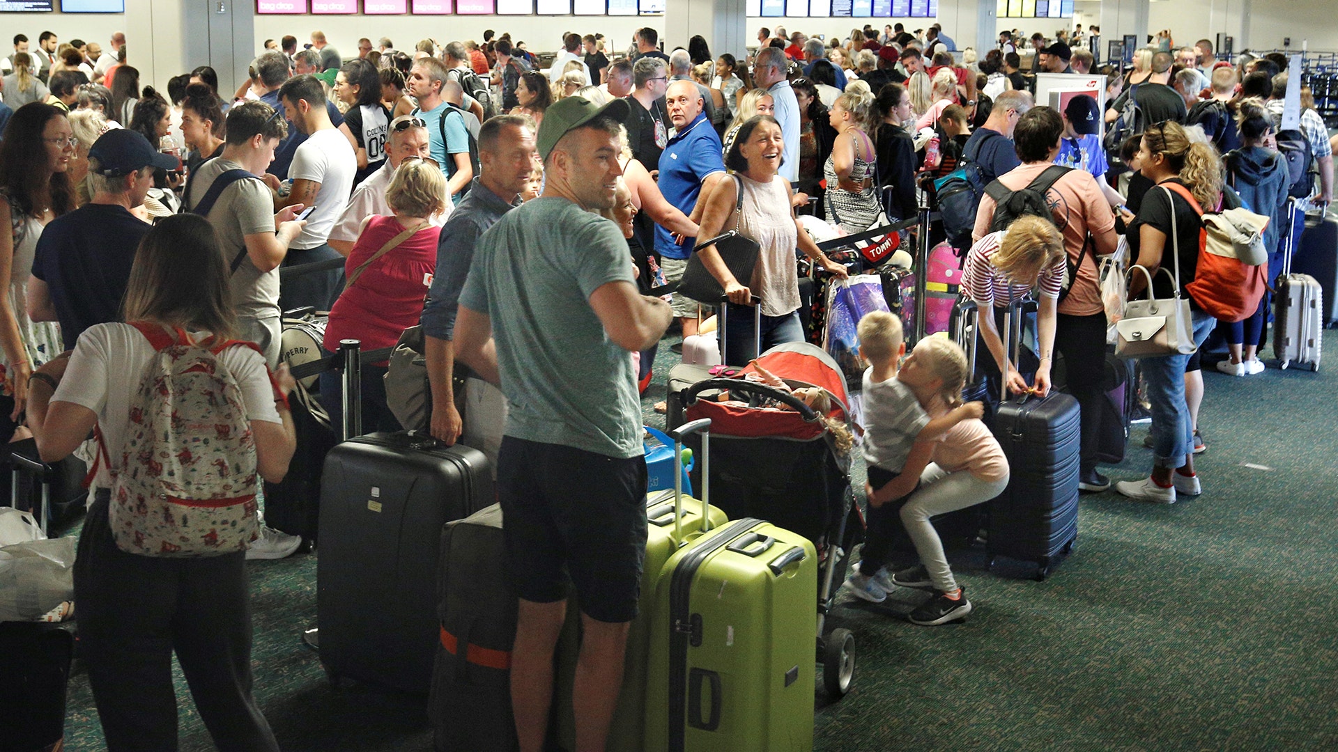 Departing passengers form a long queue to check in at Orlando International Airport 