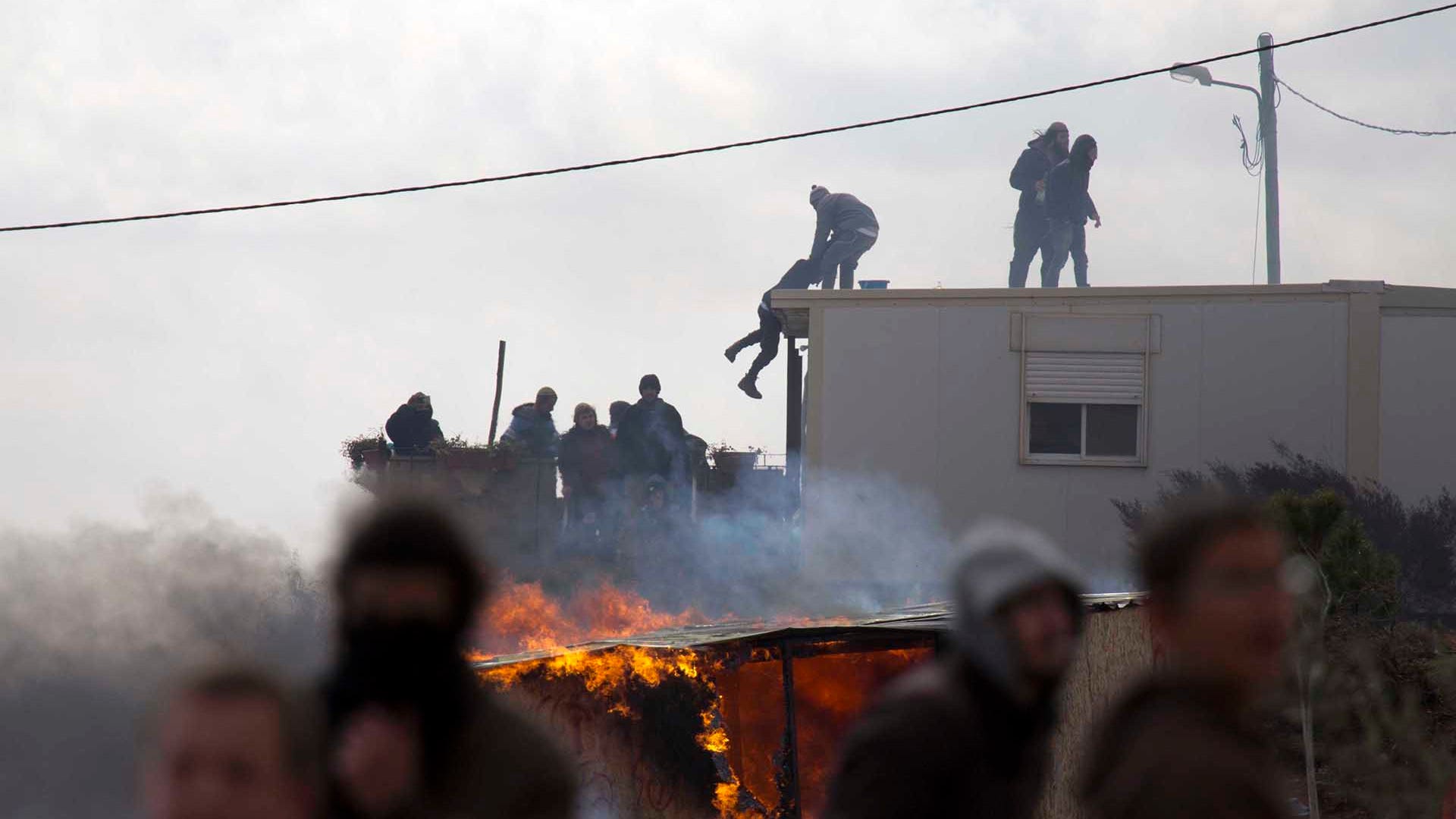 Settlers climb on top of a trailer in Amona outpost in the West Bank.