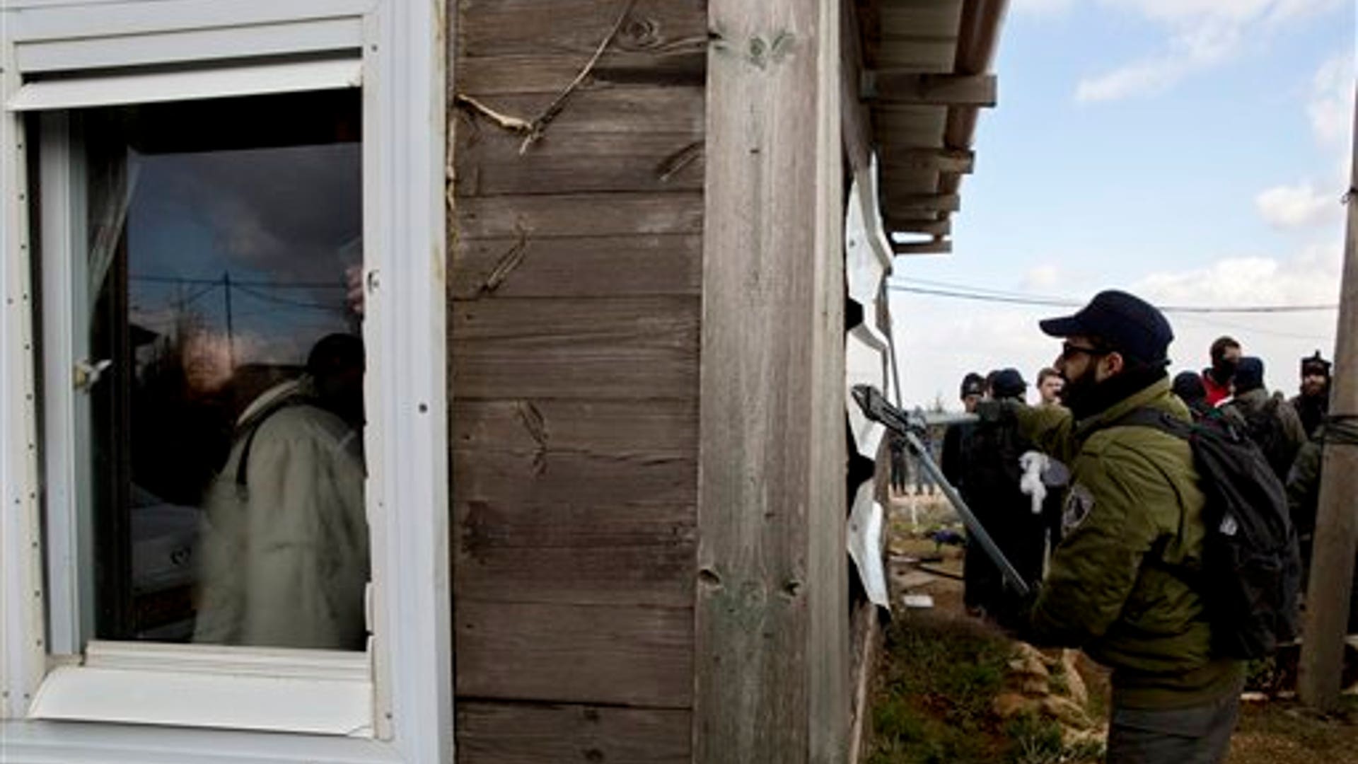 Israeli policeman using cutters in the West Bank outpost of Amona.