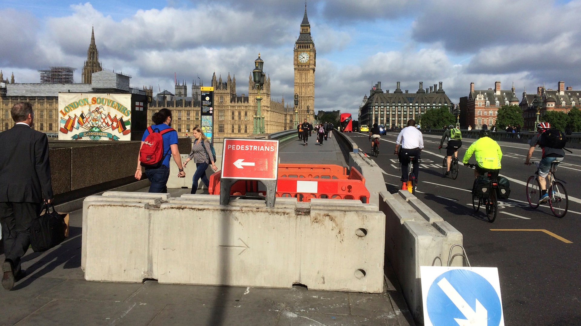 Pedestrians walk past newly erected barriers separating the road from the pavement on Westminster Bridge