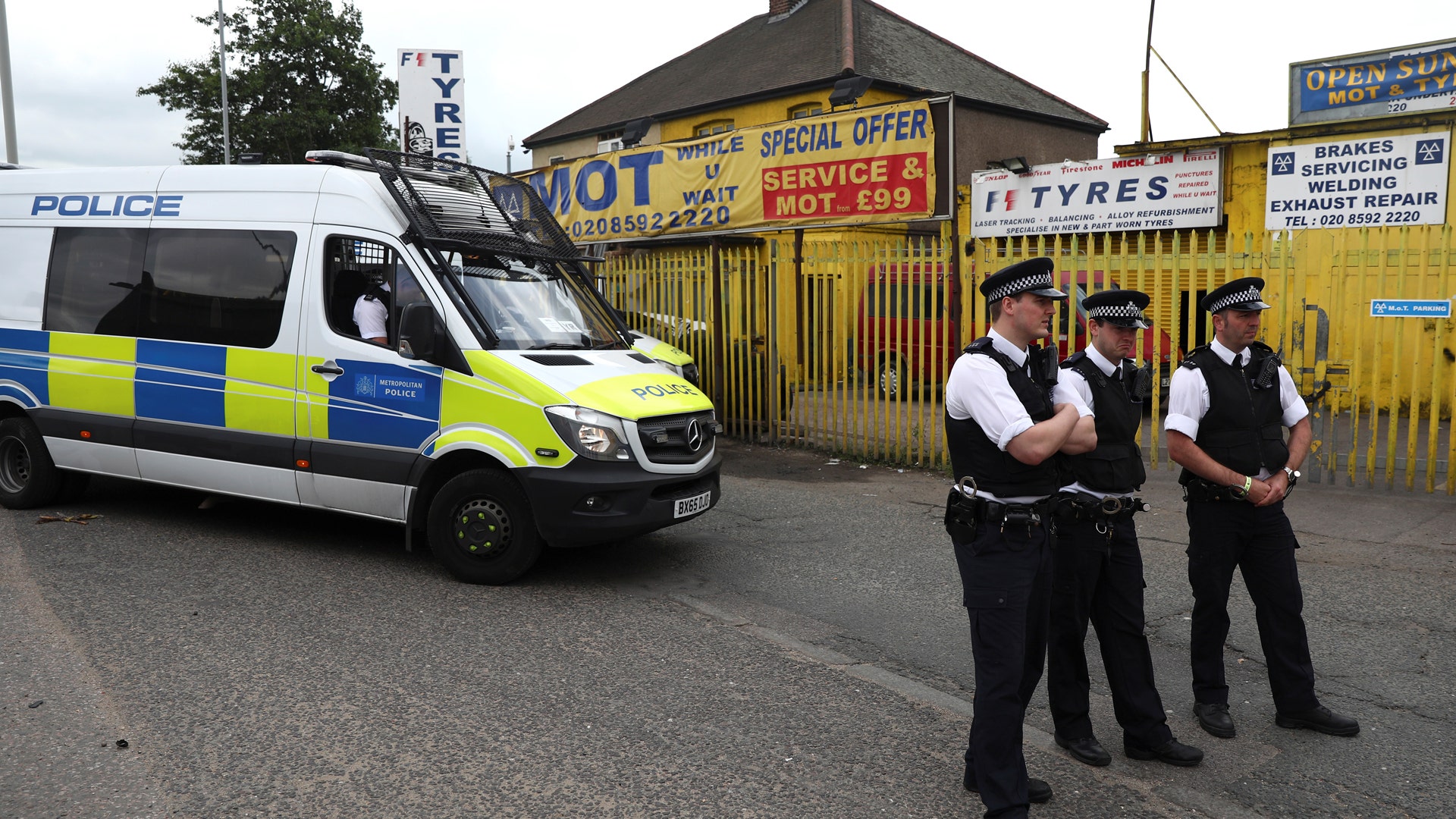 Police officers stand outside a property which was raided in Newham, east London
