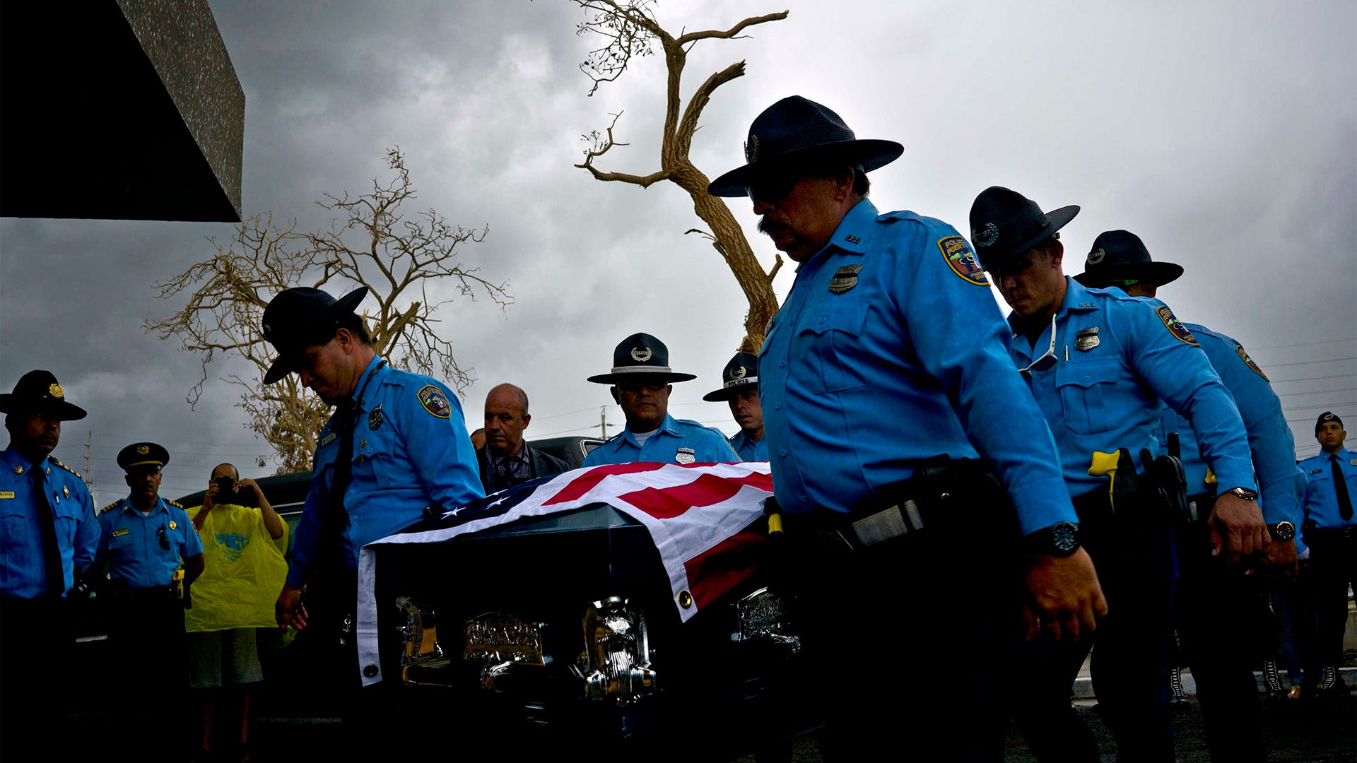 Honor guards carry the coffin of Puerto Rican police officer Luis Angel Gonzalez Lorenzo who was killed while trying to cross a river flooded by Hurricane Maria.