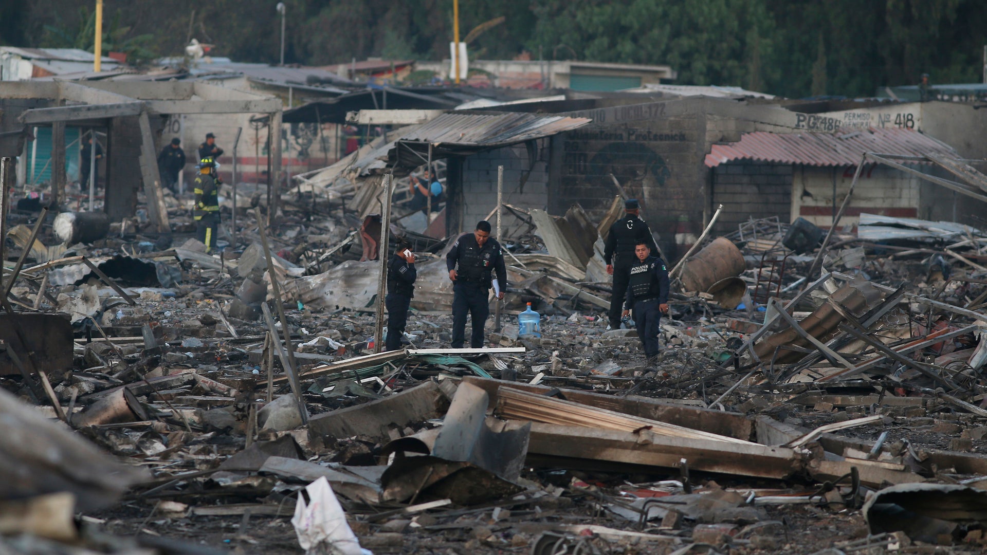 Local policemen walk through the scorched ground where the open-air San Pablito fireworks market stood. The explosion destroyed Mexico’s best-known fireworks market, injuring scores and killing dozens, according to Mexican Federal Police.
