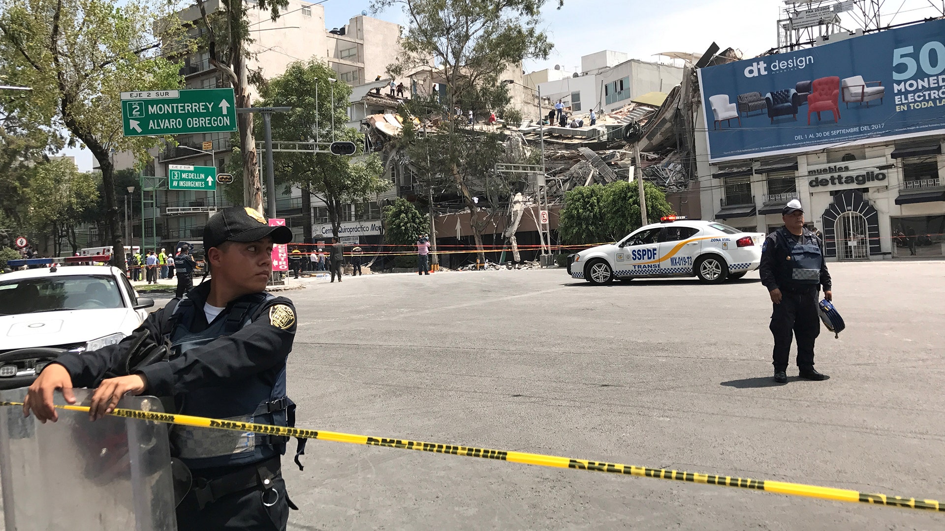 People remove debris on top of a collapsed building 