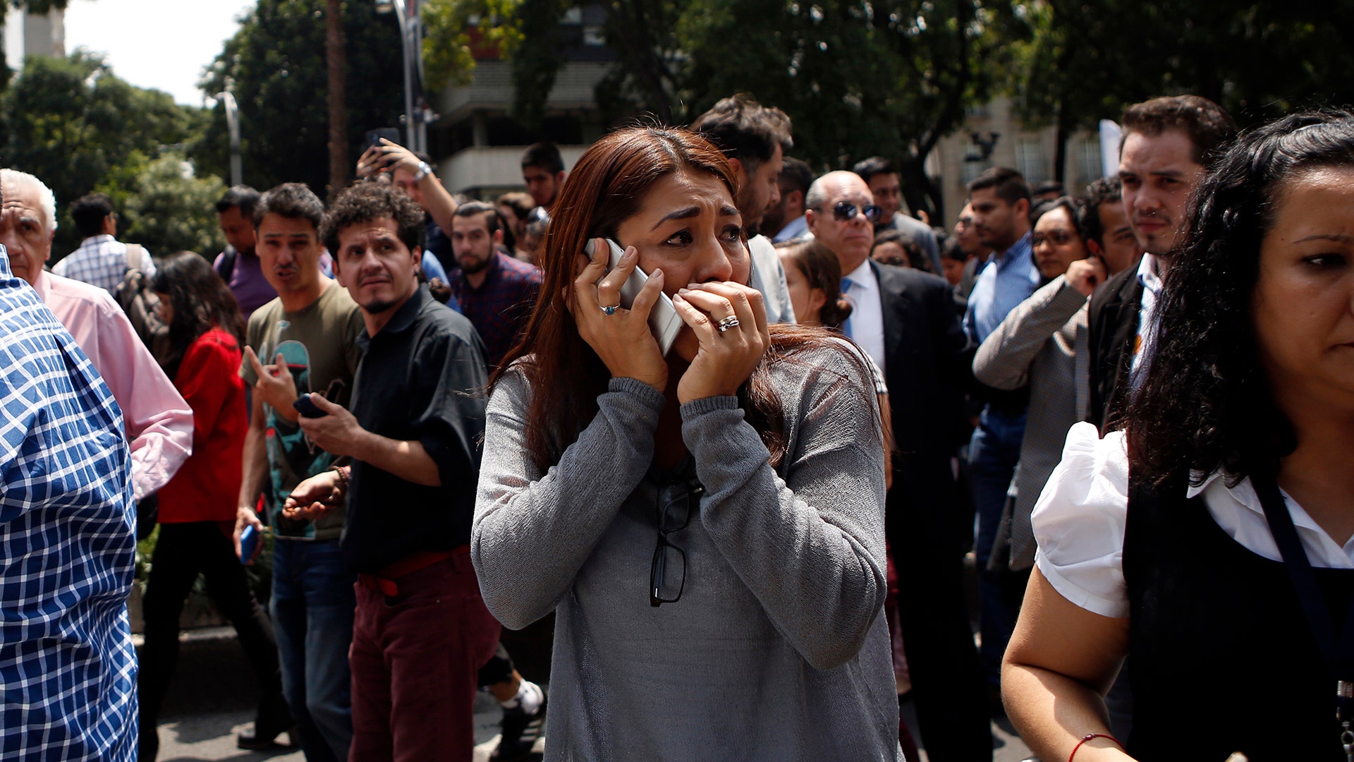 A woman speaks on her cell phone as people evacuated from office building 