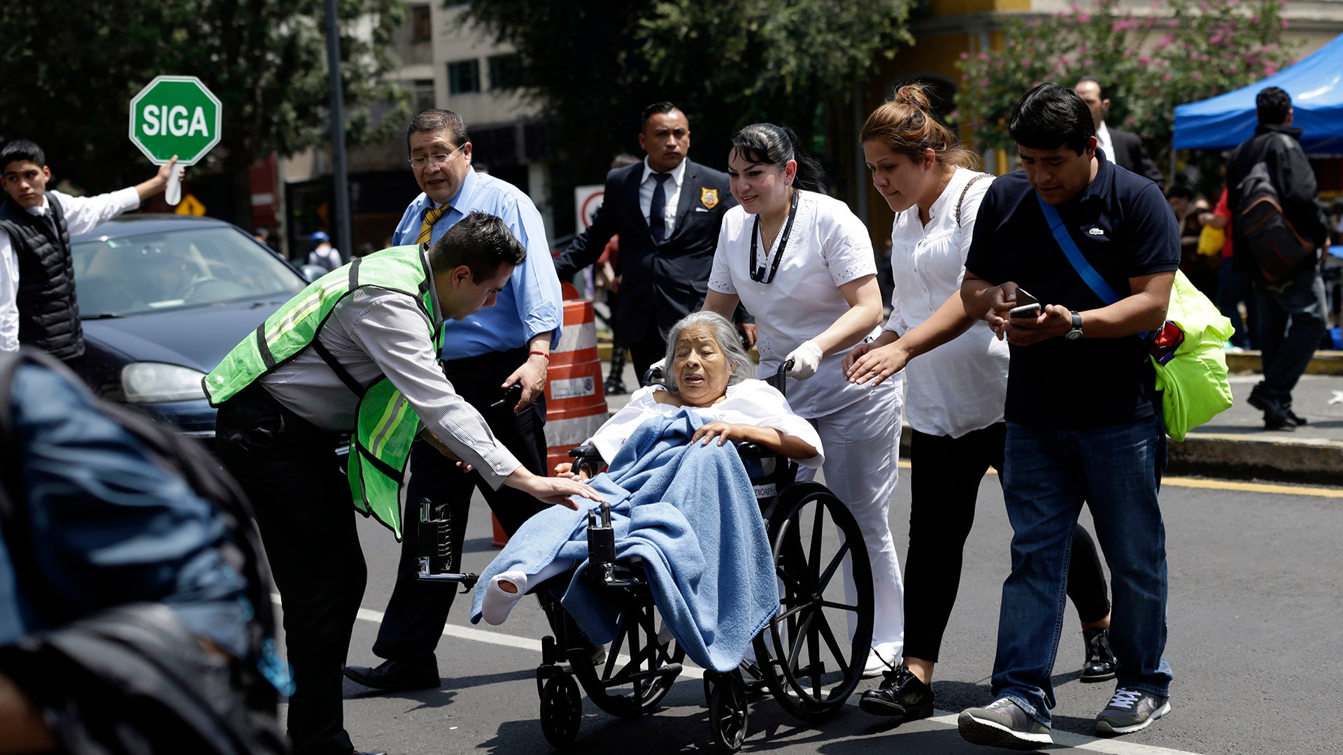 A woman in a wheelchair is evacuated from a clinic 