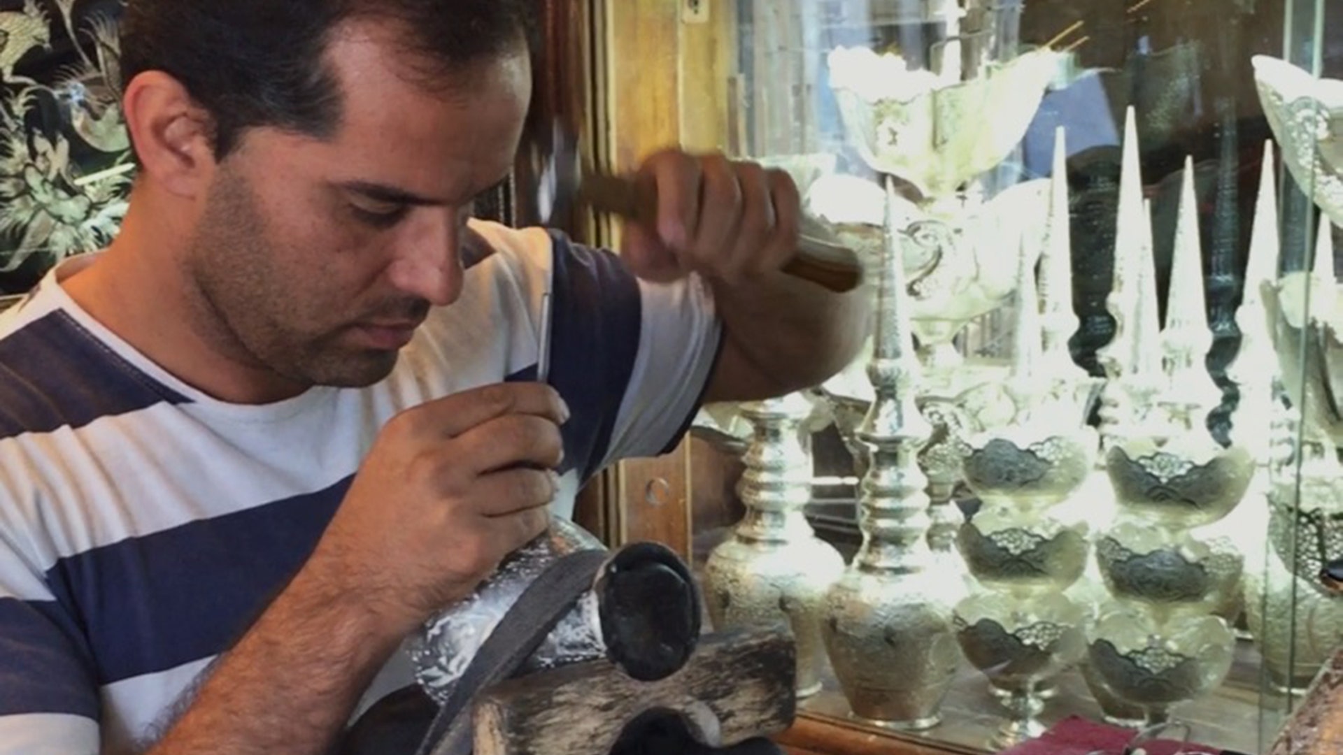 Man doing crafts inside his shop in Isfahan