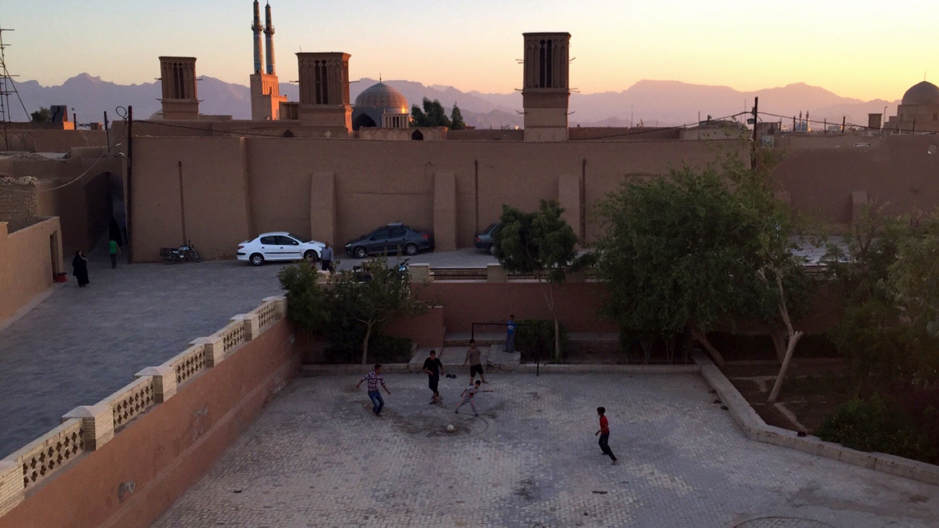 Children playing soccer at sunset in Yazd