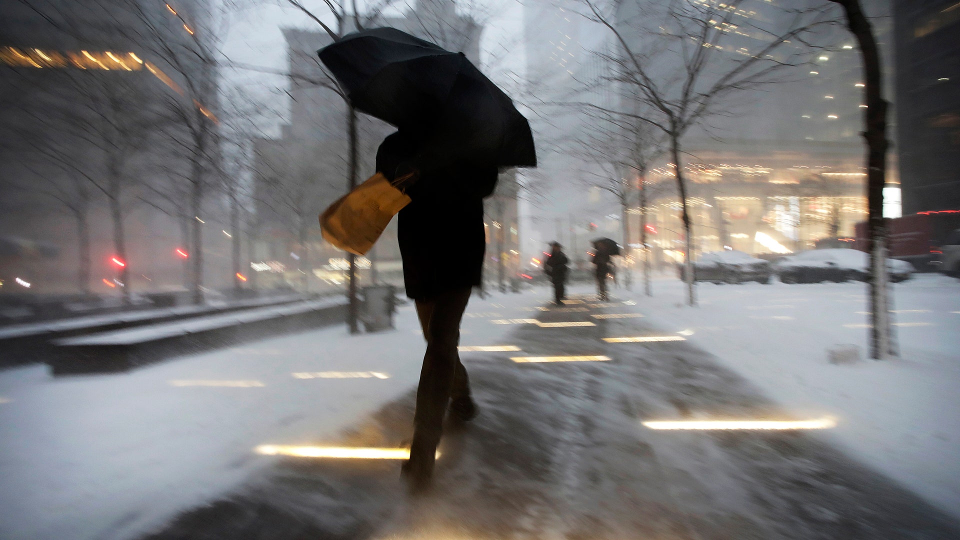A man makes his way through wind and snow in New York's Zuccotti Park, Thursday, Feb. 9, 2017. 