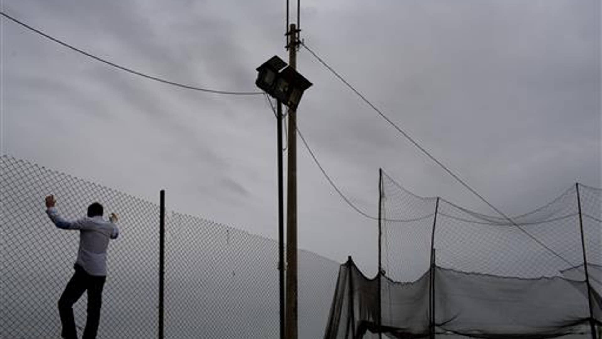 peru_man_climbing_fence