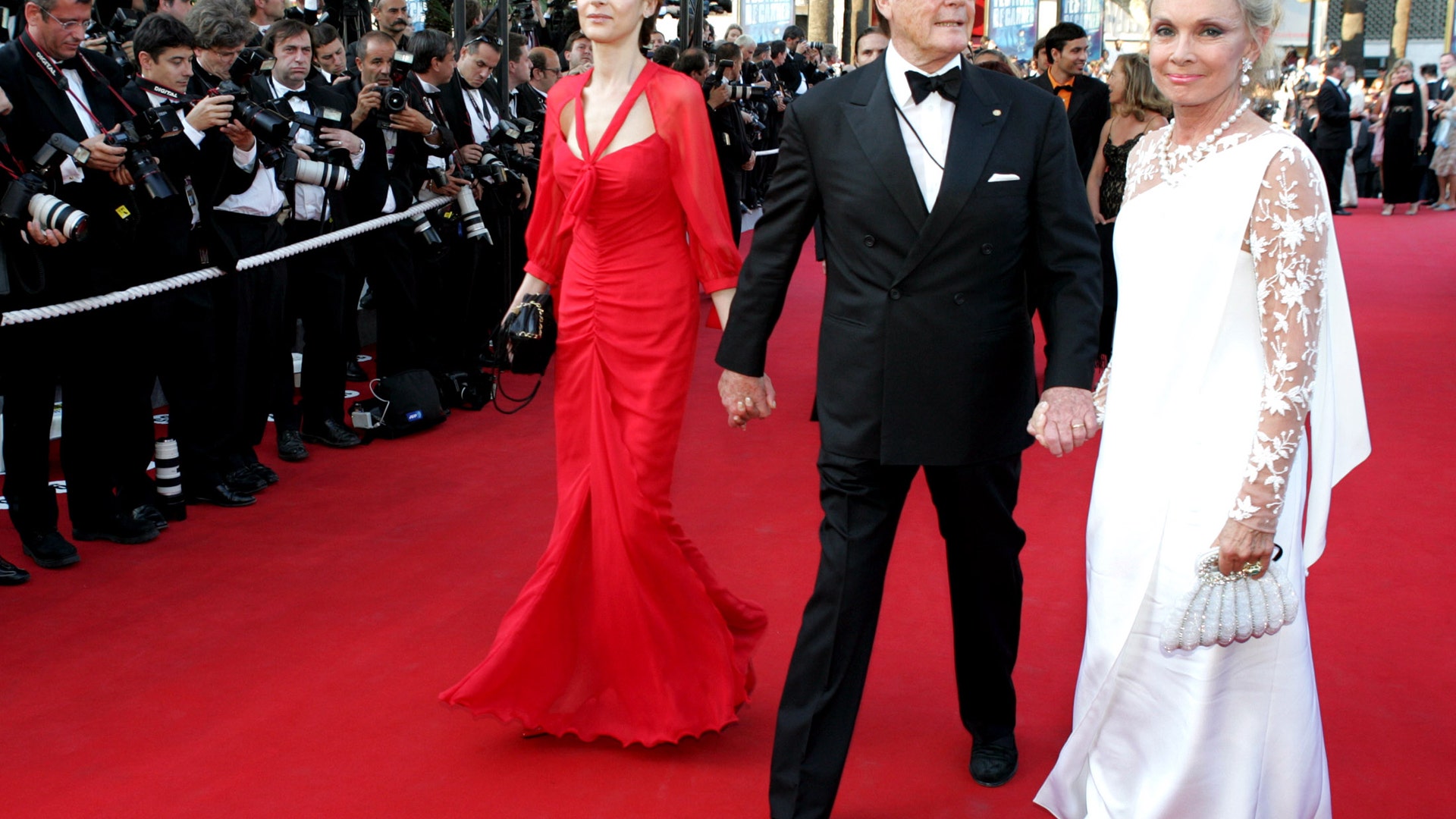 Moore escorts his wife Christina Tholstrup and daughter Deborah Moore on the red carpet at the 57th Cannes Film Festival, May 18, 2004