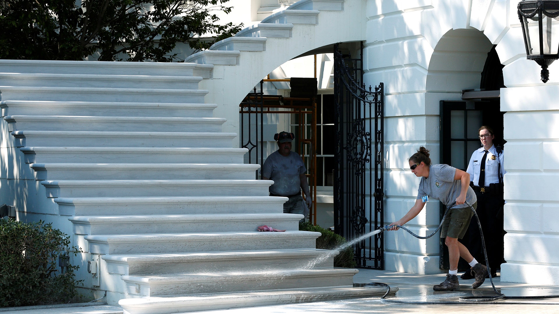 A worker cleans the South Portico porch stairs of the White House after a renovation in Washington