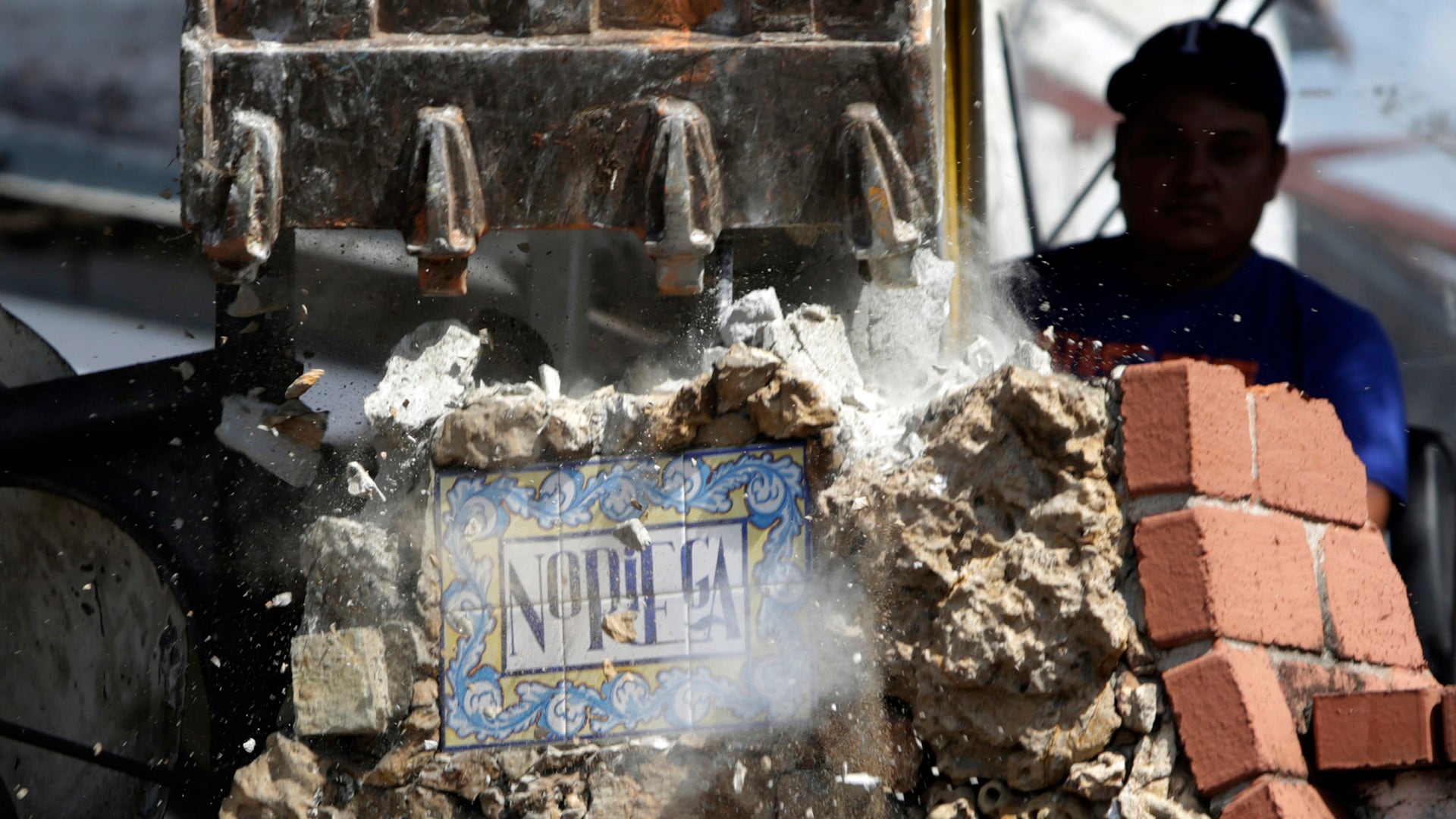 Home of former dictator Manuel Antonio Noriega in Panama City being demolished by a government worker.