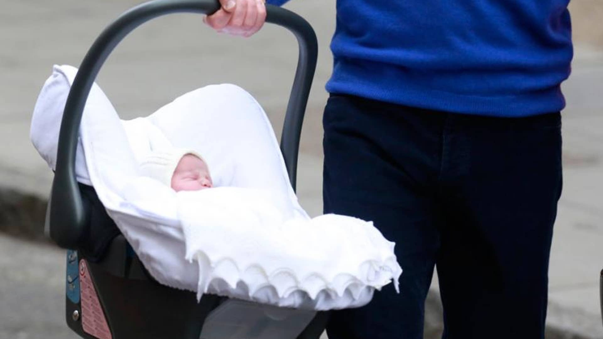 Britain's Prince William carrying his baby daughter in a car seat