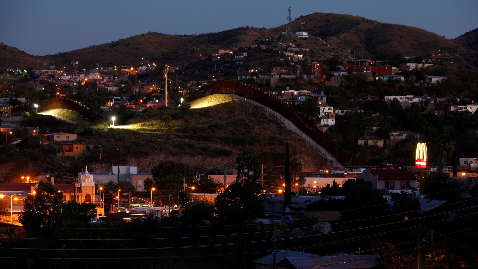 A fence separates the border towns of Nogales, Mexico (R) and Nogales, Arizona, United Sates.