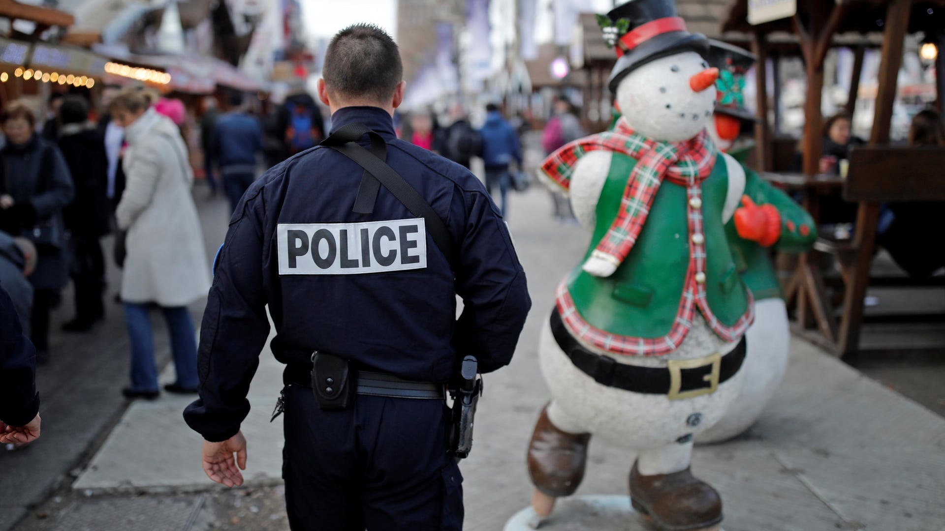 French police officer patrols a Christmas market amid heightened security on the Champs Elysees Avenue in Paris.