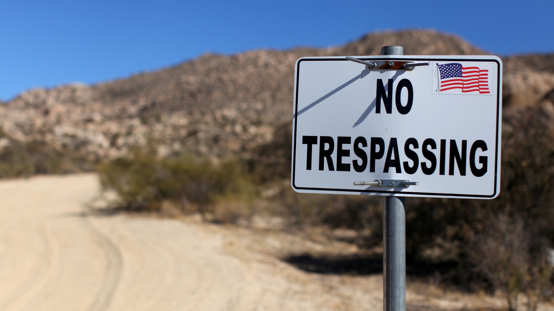 A sign stands on a private property near the U.S.-Mexico border fence near Jacumba, California.